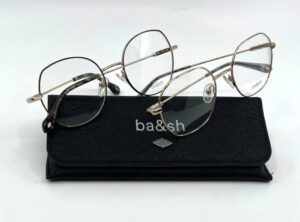 Deux lunettes Ba&sh métal doré posées sur leur étui